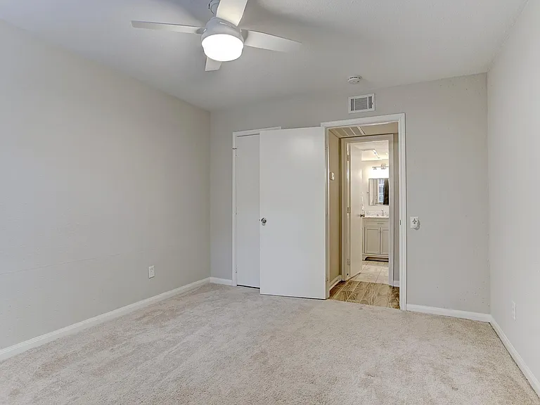 Large bedroom with brand new remote-control fan and walk-in closet - view without furniture.