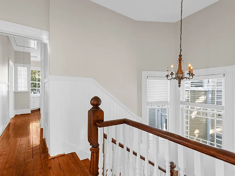 Top of the Stairs with a View into Master Suite Hallway Leading to Master Bathroom and then to the Vanity