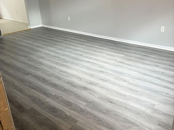 Large living room freshly painted with new flooring and windows