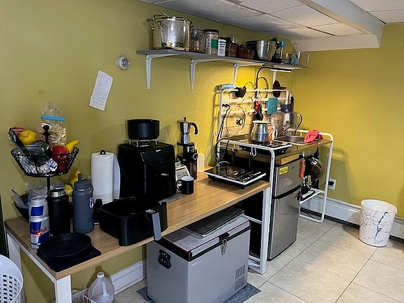 Kitchenette with hot stove and fridge and sink.