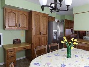 Kitchen is open  for breakfast eating area & new refrigerator. Enjoy the built-it desk area & custom cabinetry.