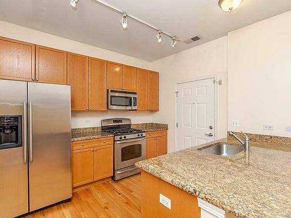 Kitchen w/ hardwood, granite, SS appliances