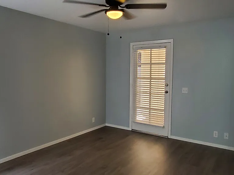 Master bedroom window and 4th entrance door with blinds, ceiling fan. Door goes out to a small private patio