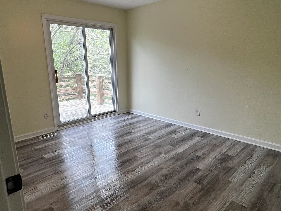 Main floor primary bedroom features a deck overlooking the backyard.