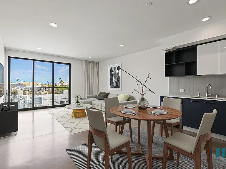 Open-Concept Kitchen, Dining, and Living Room Space with Concrete Flooring and Patio