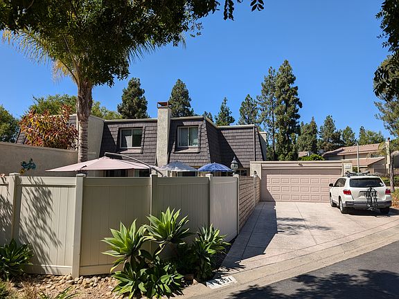 Two car garage and three car driveway next to the fenced-in yard