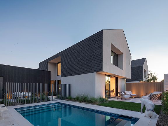The home comes alive at dusk, with warm architectural lighting, a private heated pool, outdoor lounge areas, and a relaxed indoor/outdoor lifestyle.