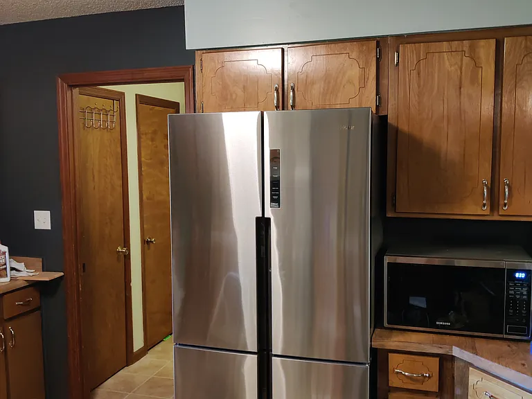 Fridge and entryway that leads to the laundry room and garage.