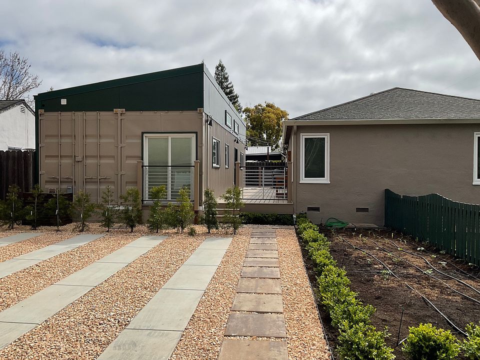 Available ADU Unit B is the structure on the left with parking pad in front of it, main house on the right