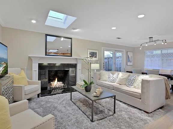 Living room with skylights, fireplace and sliding door to deck