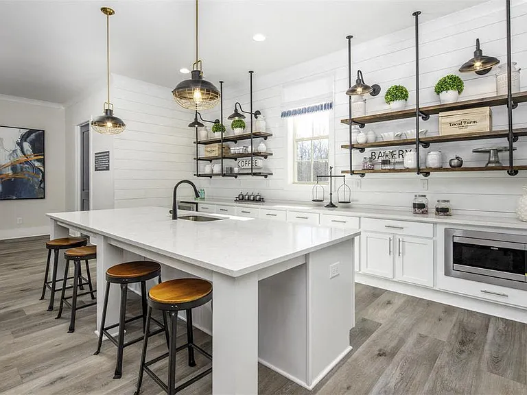 Kitchenette inside the clubhouse with bar seating, mini fridge and sink.