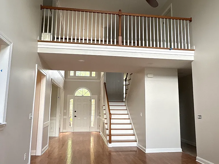 Upstairs bridge connects bedrooms on either side. (Photo is compressed to include both sides of great room)