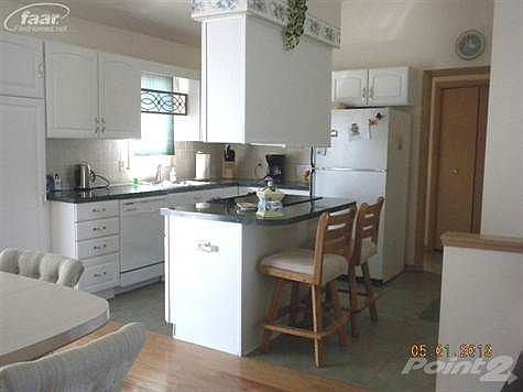 Kitchen, showing island, newer cabinets, counter top and flooring.