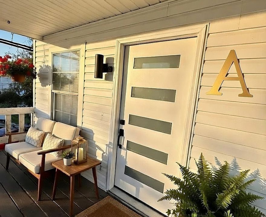 Large front porch overlooking lawn, brand new front door with windows for natural light, modern lighting, and more!