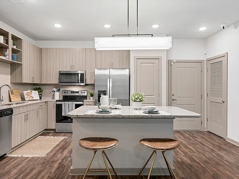 Modern kitchen with sleek cabinetry, stainless steel appliances, and a stylish island with seating. Ideal for culinary enthusiasts.