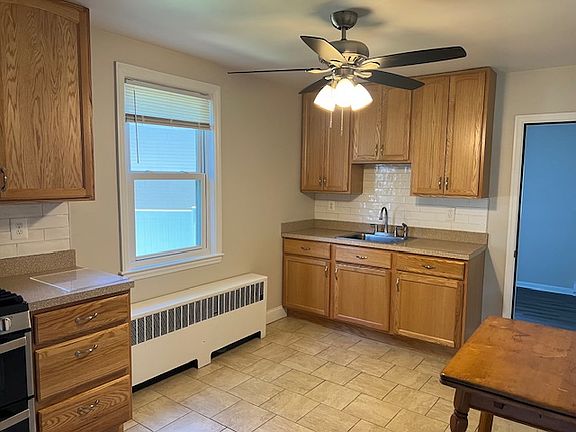 Spacious kitchen with tile floor, new ceiling fan, pantry.