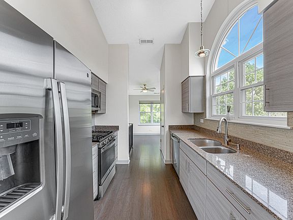 Kitchen: A modern kitchen with sleek appliances, countertops, and cabinets, shown from different angles (three photos).