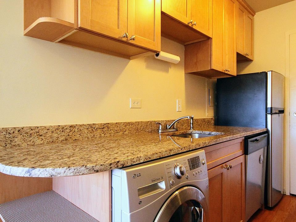 Updated kitchen with granite countertops, stainless steel appliances, and a washer/dryer unit