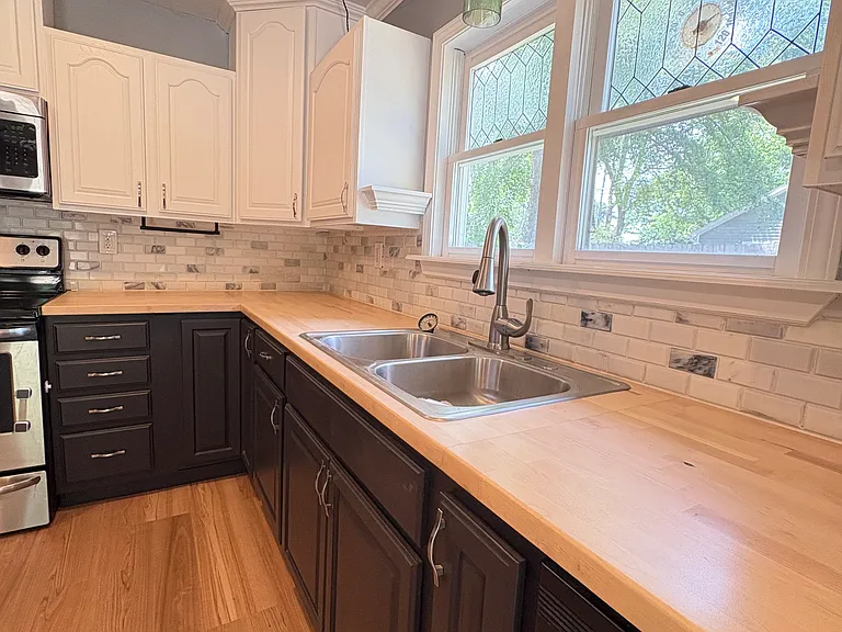 This colonial cottage is rich with unique details that add both character and convenience. The handcrafted faux stained-glass windows and cleverly integrated paper towel holder are just a glimpse of the home's thoughtful design.