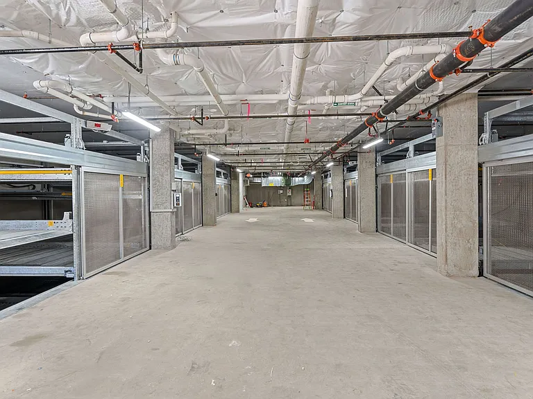This secure storage area features steel cages and a concrete floor, providing a safe and organized space for storing belongings.