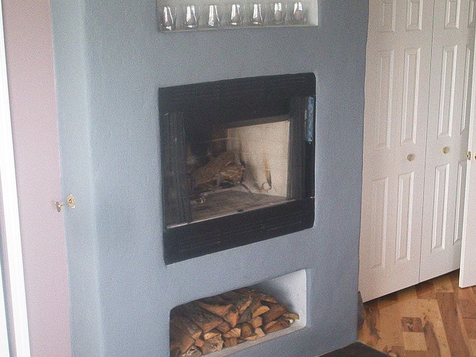stucco fireplace w/arched top and firewood holder, slate hearth w/mirror inlay