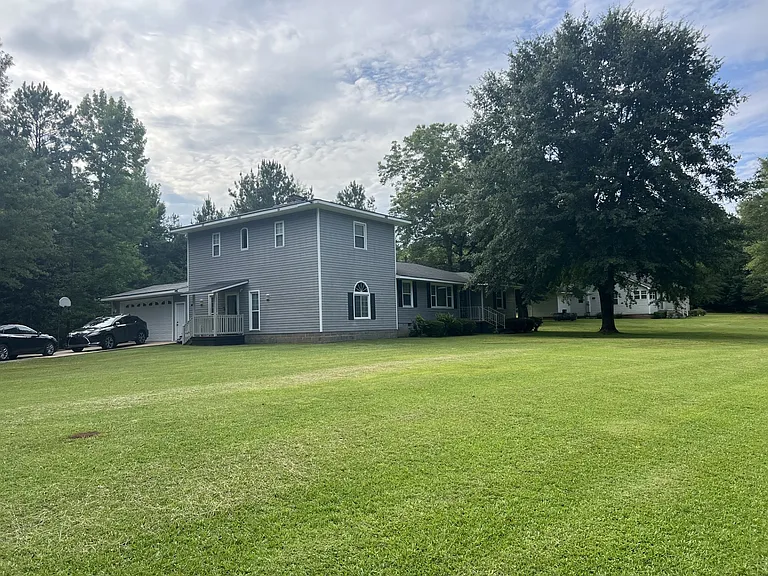 Side view with small porch. Driveway parking.