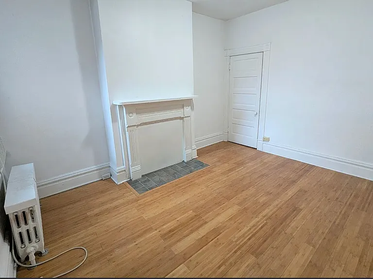 2nd Floor Middle Bedroom a window overlooking the garden, a good sized closet (closet door seen here), warm hearth/fireplace, and natural light