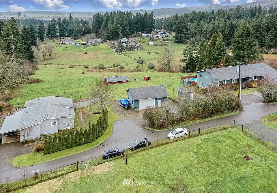 Drone view of front of property: Main house on right, amazing shop in middle and spacious triple-wide on left. Note that all 3 buildings have their own driveways. 