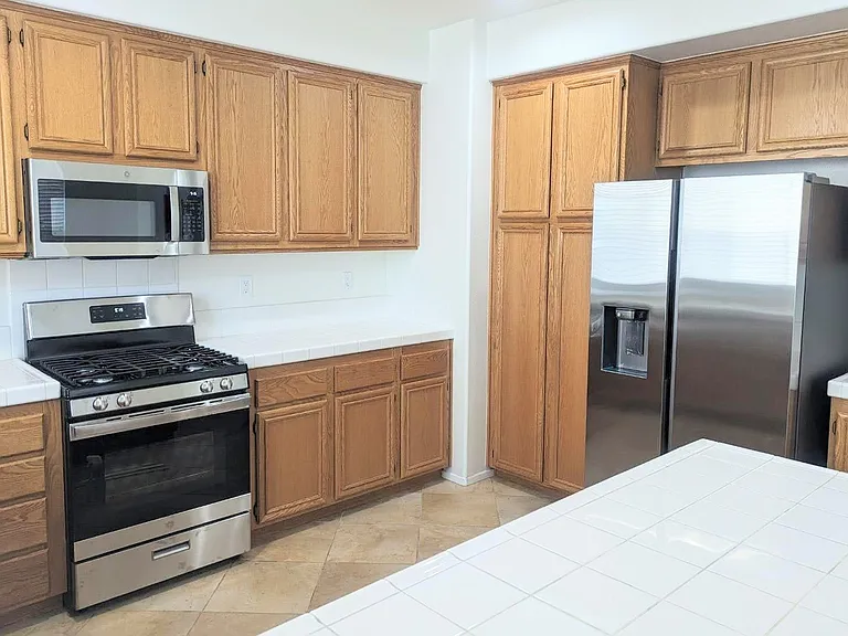 This picture shows the brand new stainless steel appliances in the kitchen (dishwasher, microwave, stove, and refrigerator). All of the appliances come with the house.