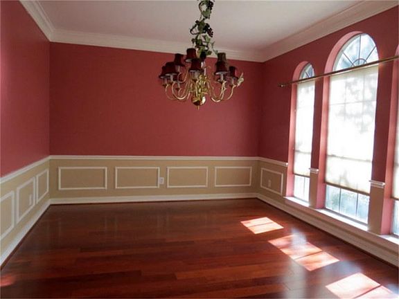 Large formal dining room w/custom paint, chair rail, wood flooring.