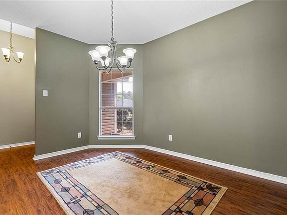 Empty room with baseboards, a chandelier, and wood finished floors