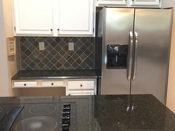 cooktop and granite island, stainless fridge