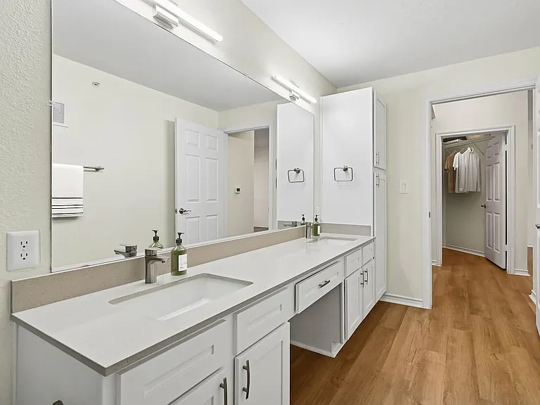 Renovated Package I bath with grey quartz countertop, white cabinetry, and hard surface flooring