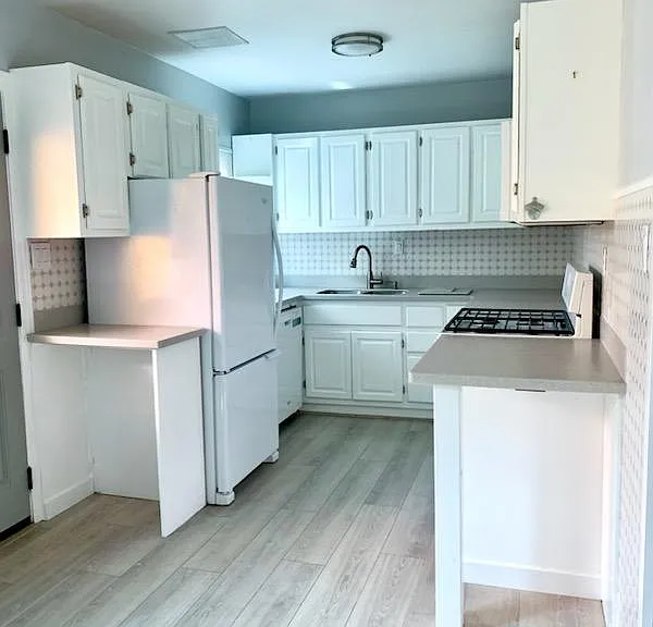 Fresh, bright kitchen w like new Whirlpool dishwasher, fridge & gas stove, corian countertop and real wood cabinets