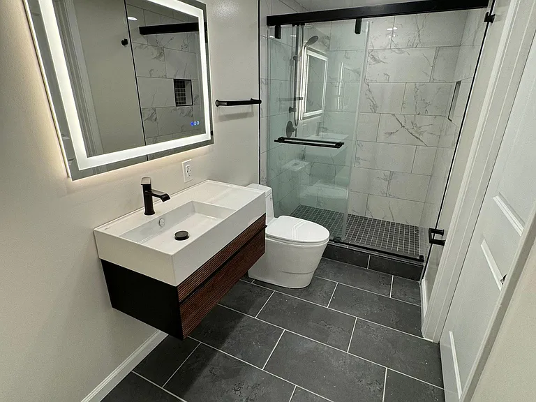 Lower level bathroom with floating vanity and LED mirror.