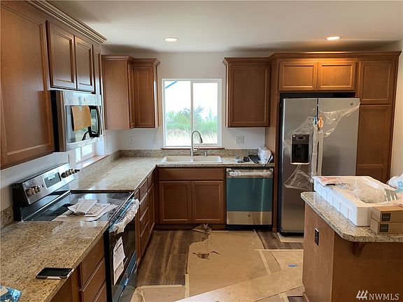 Almost finished kitchen with granite counter tops, stainless steel appliances custom sink and cabinets. Bottom left is where the wine/beverage cooler will go under the counter top!