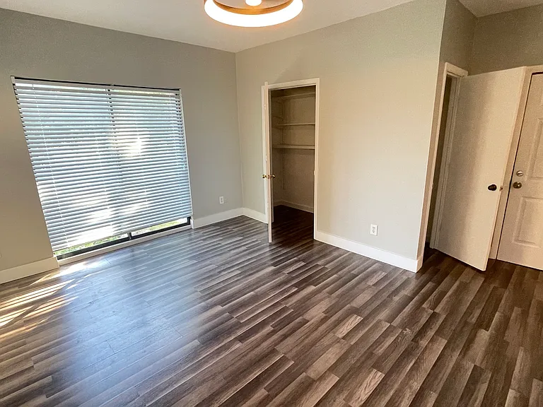 View of living/sleeping area showing Juliette balcony and closet.