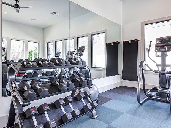 Club-quality fitness studio with free weights and elliptical. This image is a representation of the fitness studio at Amavi Brier Creek and is tentatively scheduled to open Summer 2025.