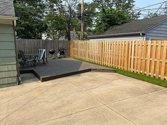 Fenced in backyard with a deck.