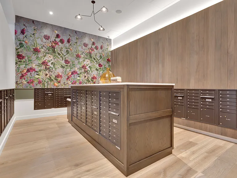 Chic mailroom interior featuring elegant wood paneling and vibrant floral mural, perfect for modern apartment complexes.