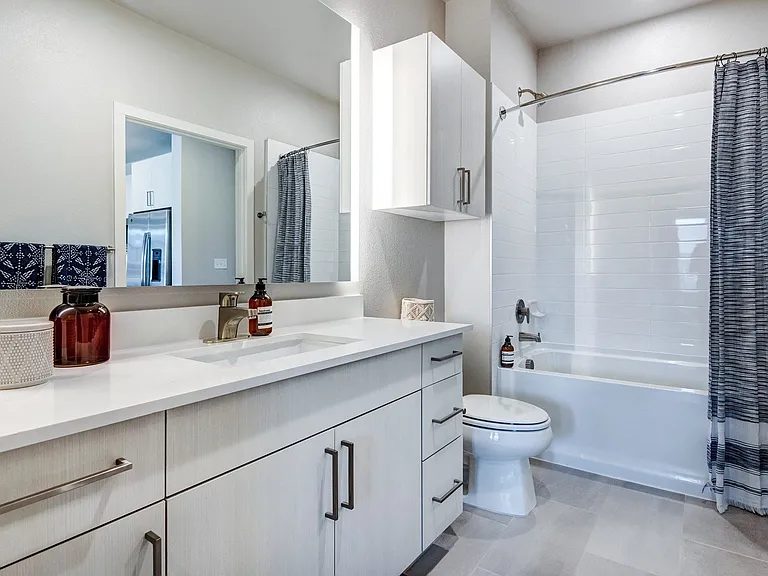 Spacious en-suite master bath with custom-framed mirror.