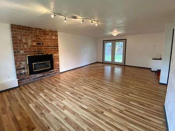 Downstairs living room with gas fireplace, access to backyard, and functional sink