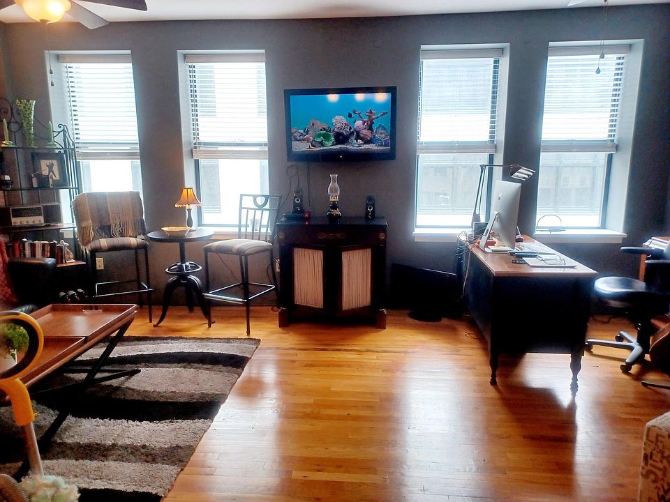 Living Room With Large Windows Looking Out With Views. New Wooden Shudders. Hardwood Floors