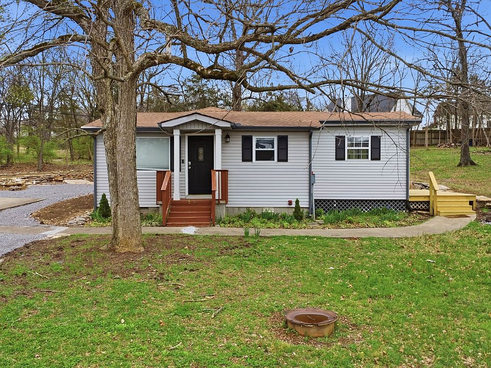 Charming front elevation with inviting entry, mature landscaping, and a quiet, private setting.