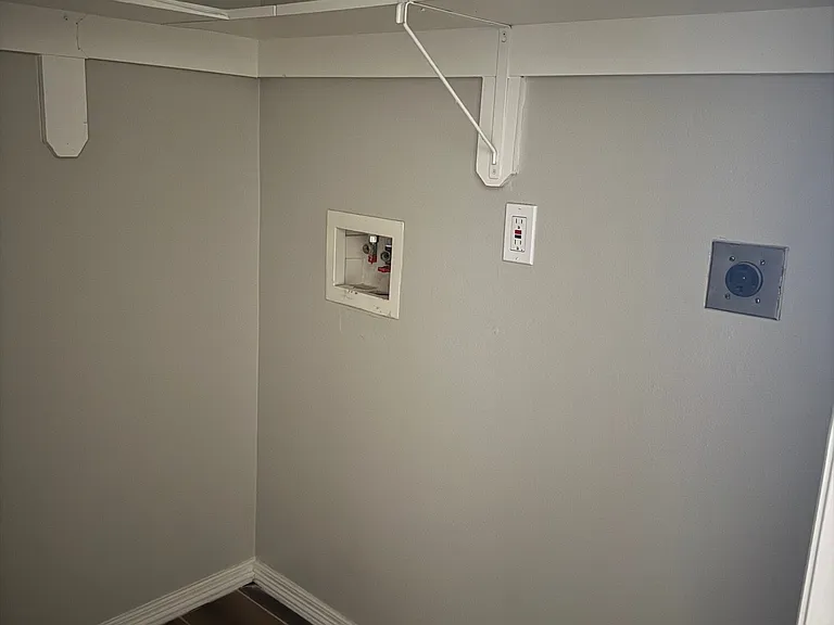 An ample laundry room with plenty of shelf space.