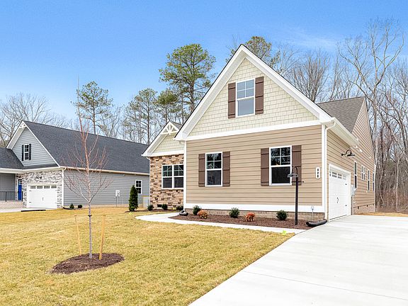 Modern Somerset Hill suburban house with beige siding, brick accents, garage, and a neat lawn under