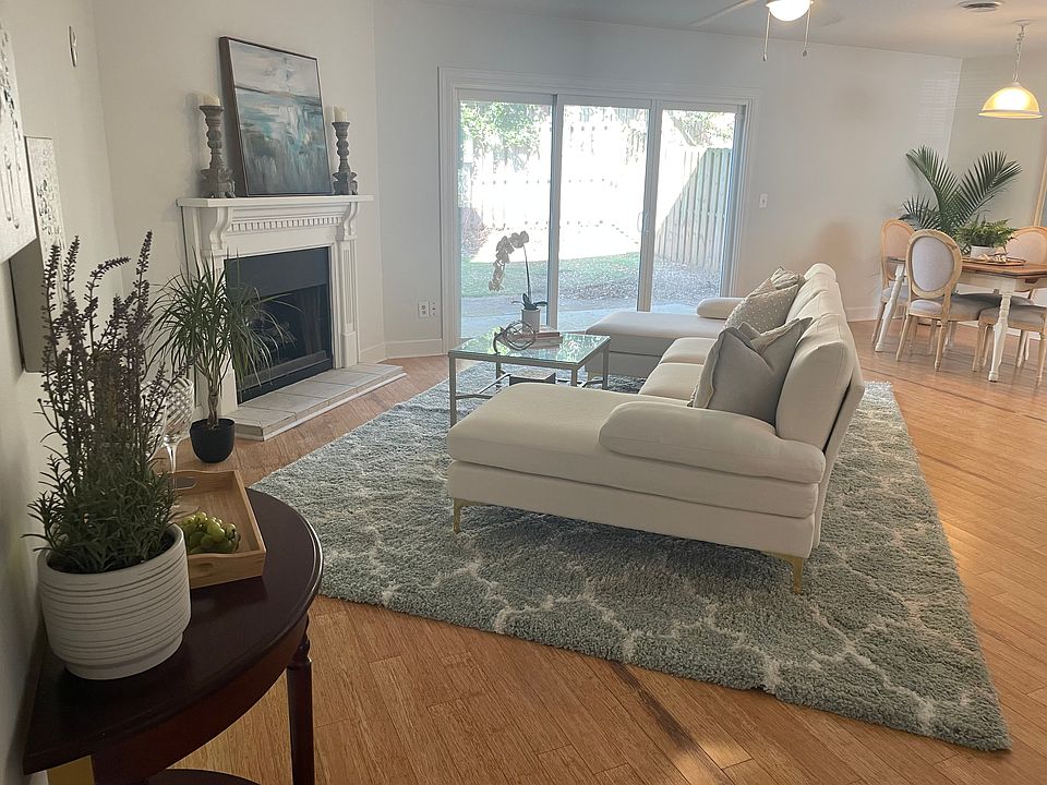 Open-concept living area with bamboo flooring, smooth ceilings, and abundant natural light