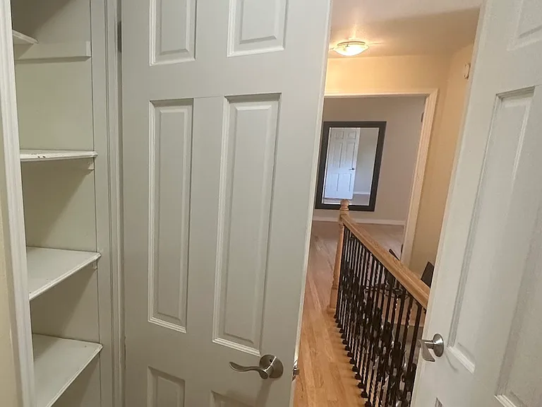 upstairs hallway facing mbr at end; two storage closets in view (near bedroom 2 and 3)