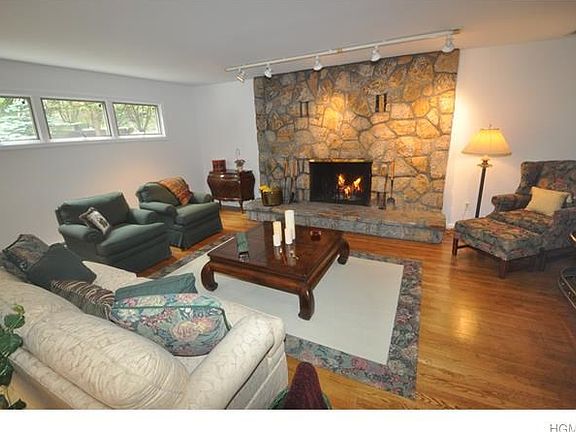 Open living room with stone faced wood burning fireplace.