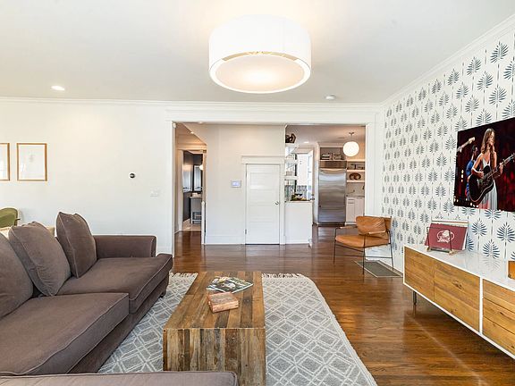 Open-concept living and dining area with hardwood floors and natural light throughout
